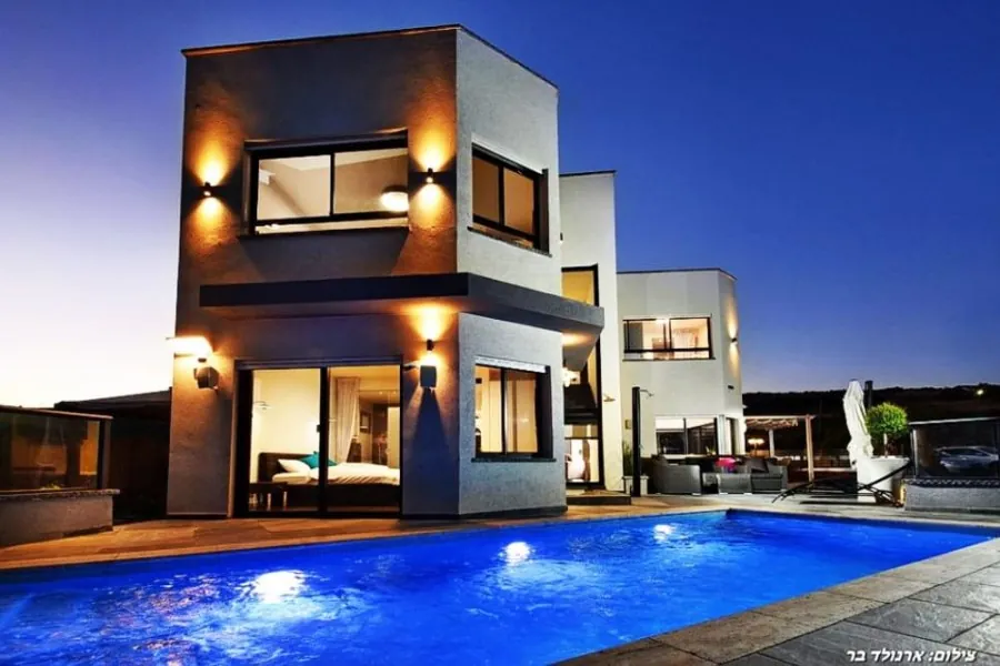Dream House – the villa and lit pool at dusk
